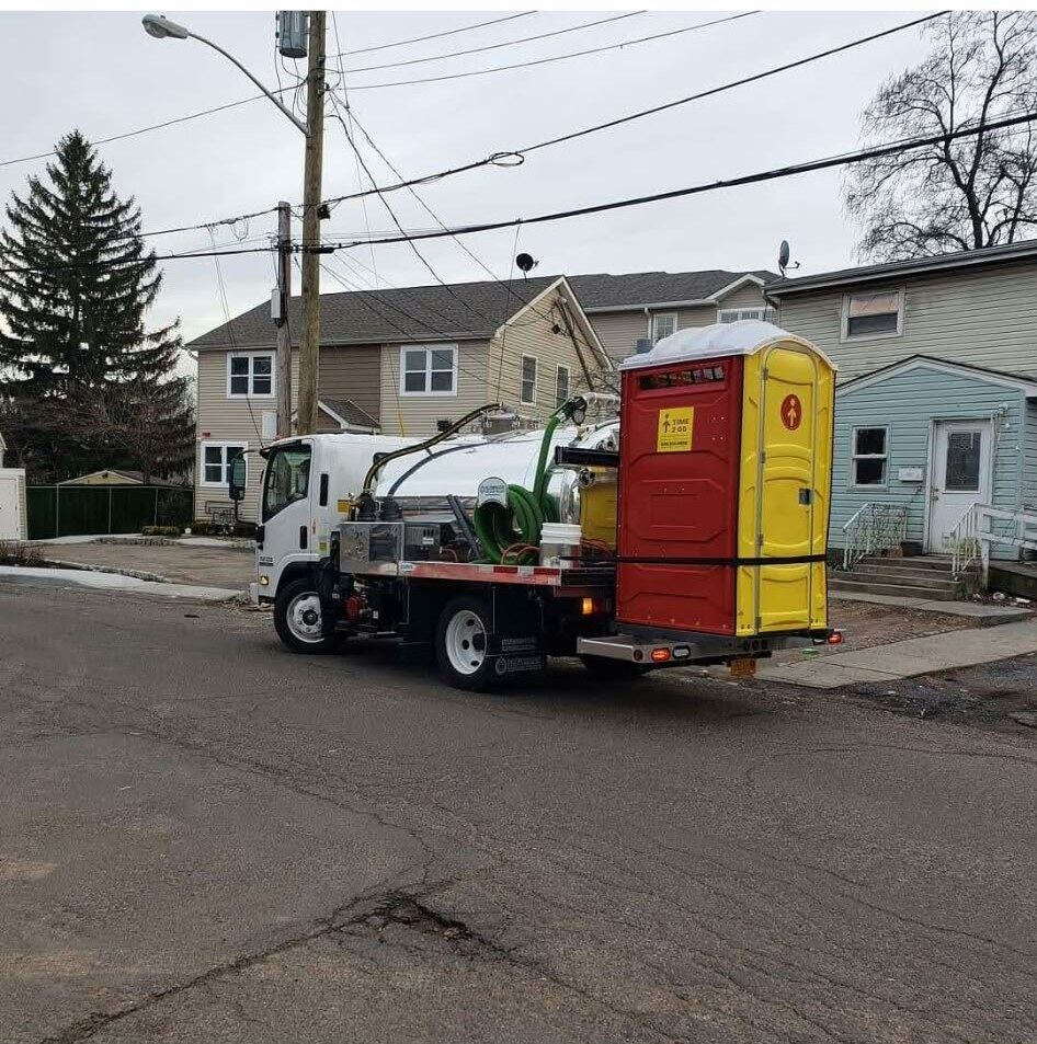 Time2go truck delivering a portable toilet unit on a residential street